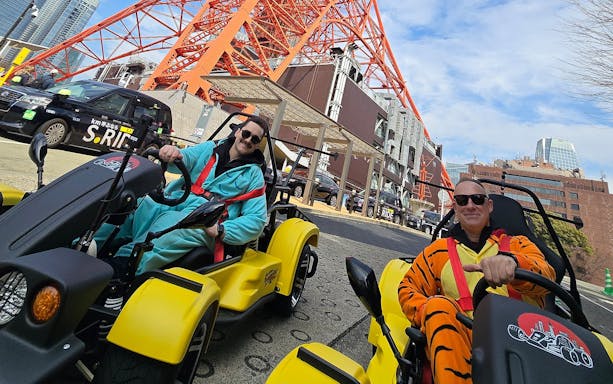Go-kart riders in costumes near Tokyo Tower on Uptown Go Kart Tour.