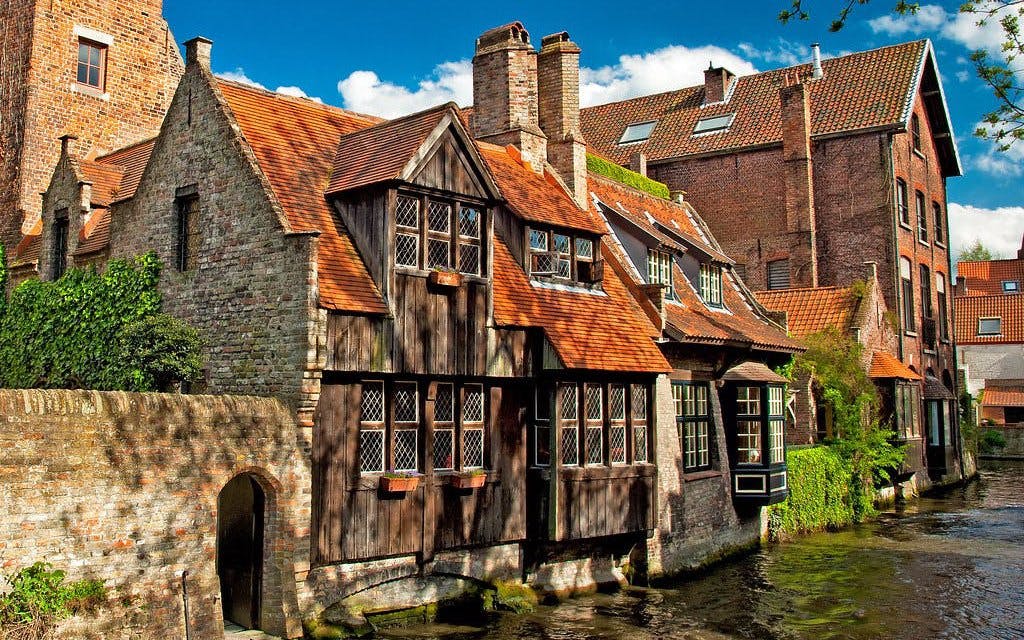 Historic brick buildings along a canal in Bruges, Belgium.
