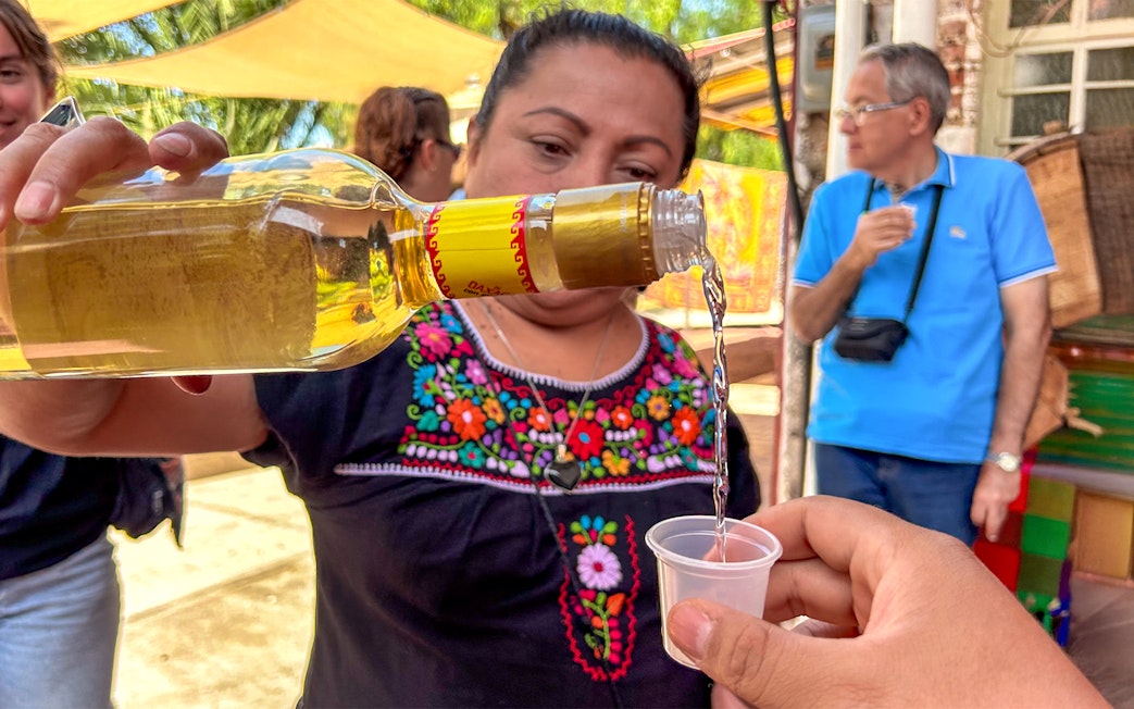 Pouring tequila into a cup during a tasting event in Mexico.