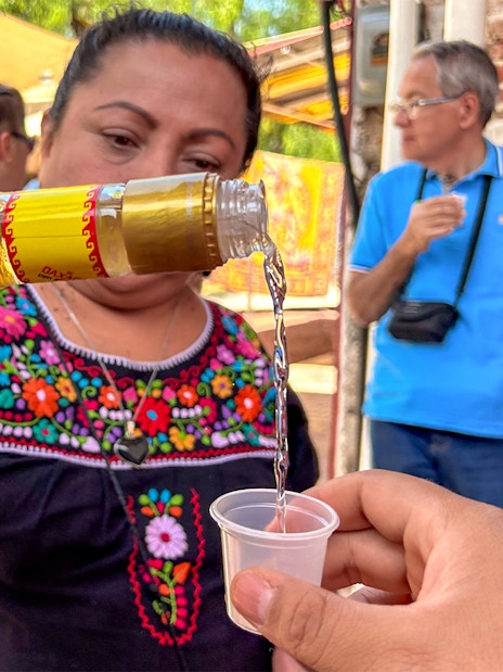 Pouring tequila into a cup during a tasting event in Mexico.