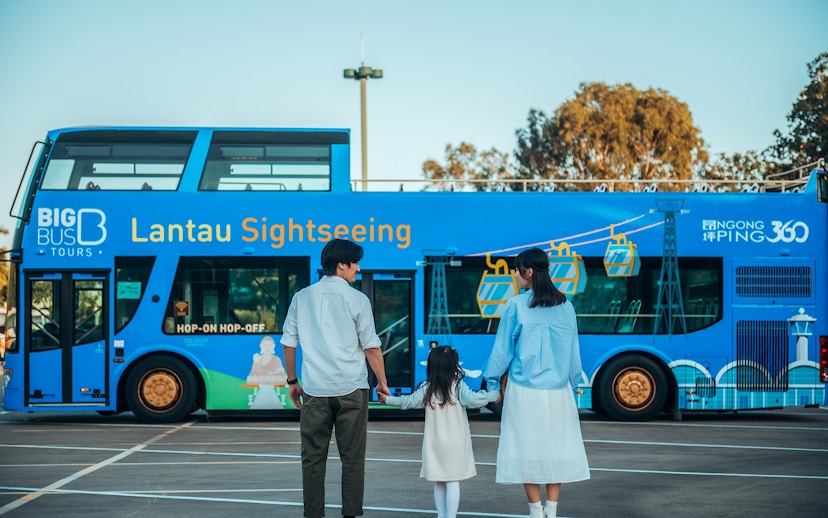 Family standing in front of BigBus Lantau Island sightseeing bus.