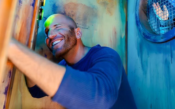 Man smiling while solving a puzzle at Prison Island Melbourne.
