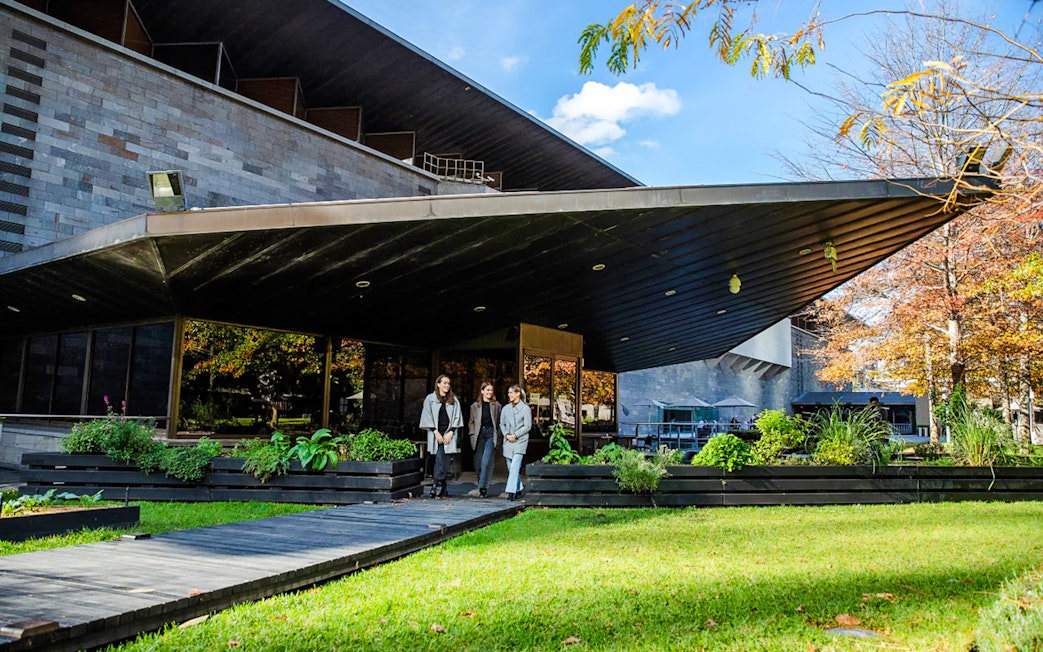 Tourists outside National Gallery of Victoria, enjoying garden view before 3-course lunch.