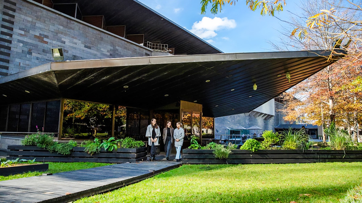 Tourists outside National Gallery of Victoria, enjoying garden view before 3-course lunch.