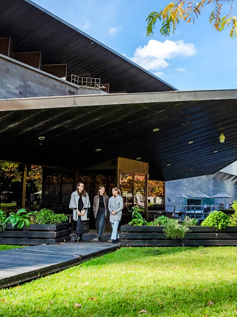 Tourists outside National Gallery of Victoria, enjoying garden view before 3-course lunch.