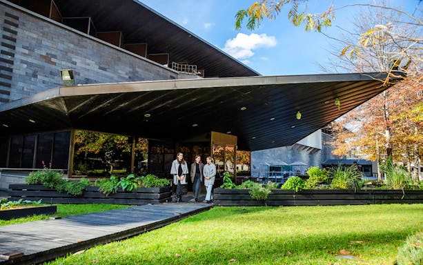 Tourists outside National Gallery of Victoria, enjoying garden view before 3-course lunch.