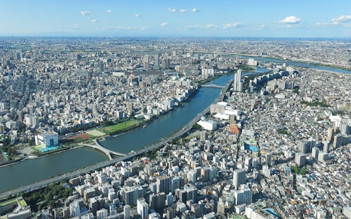 Aerial view of Tokyo cityscape from Tembo Deck and Tembo Galleria, showcasing river and urban landscape.