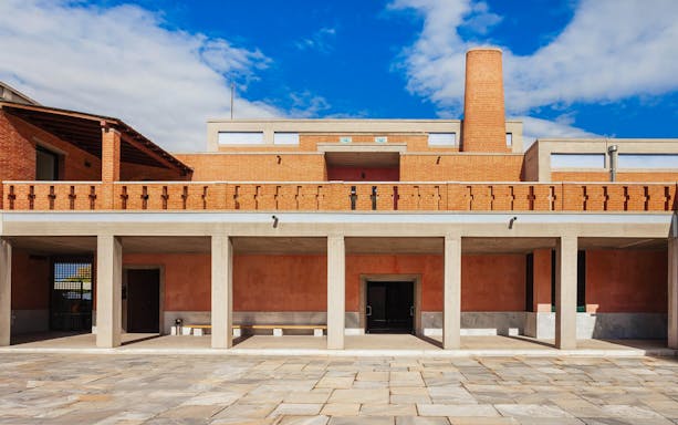Museum of Byzantine exterior with brick facade and columns under a blue sky.