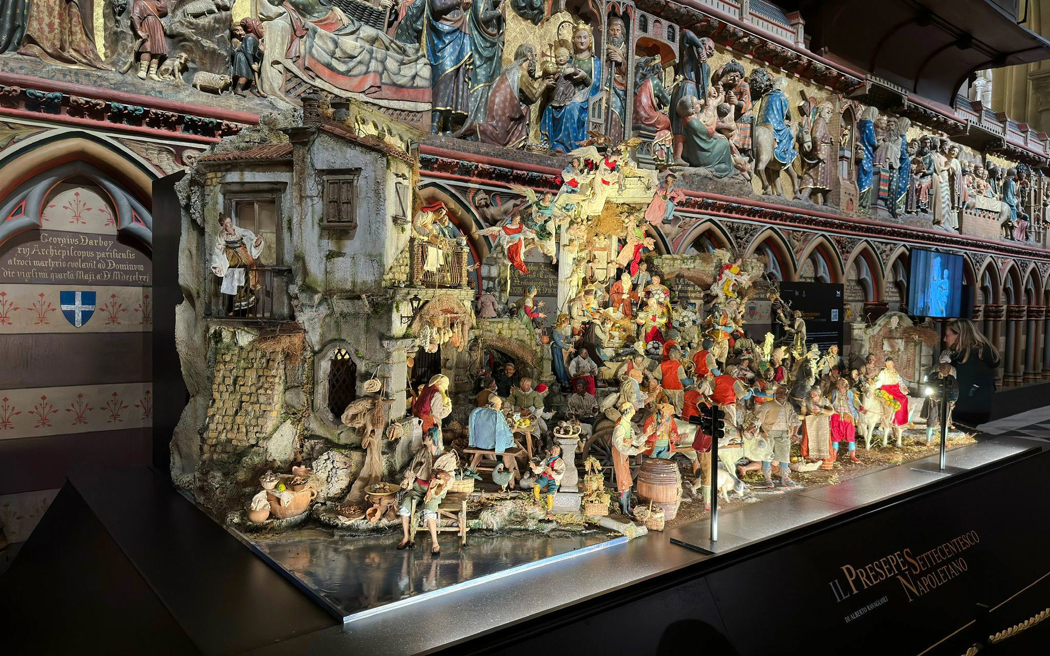 Nativity scene display inside Notre Dame Cathedral with detailed figurines and architectural backdrop.