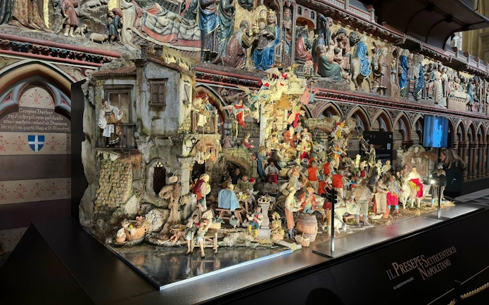 Nativity scene display inside Notre Dame Cathedral with detailed figurines and architectural backdrop.