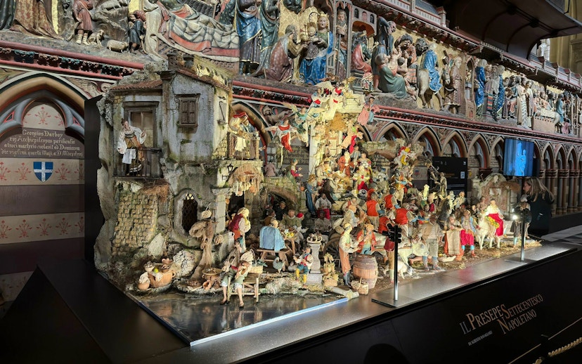 Nativity scene display inside Notre Dame Cathedral with detailed figurines and architectural backdrop.