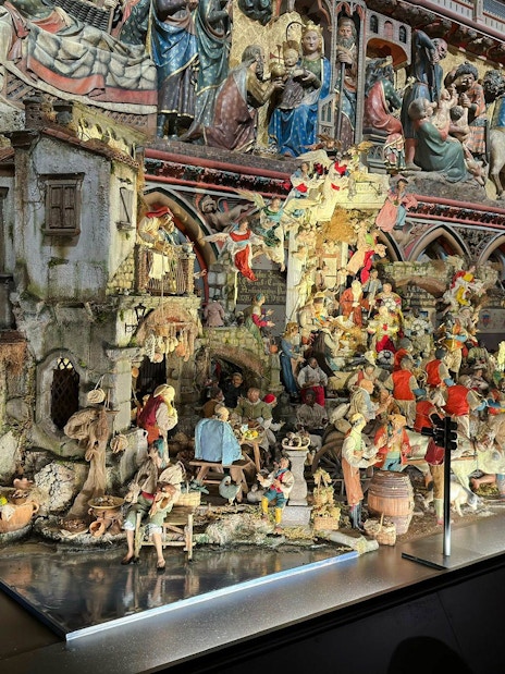 Nativity scene display inside Notre Dame Cathedral with detailed figurines and architectural backdrop.