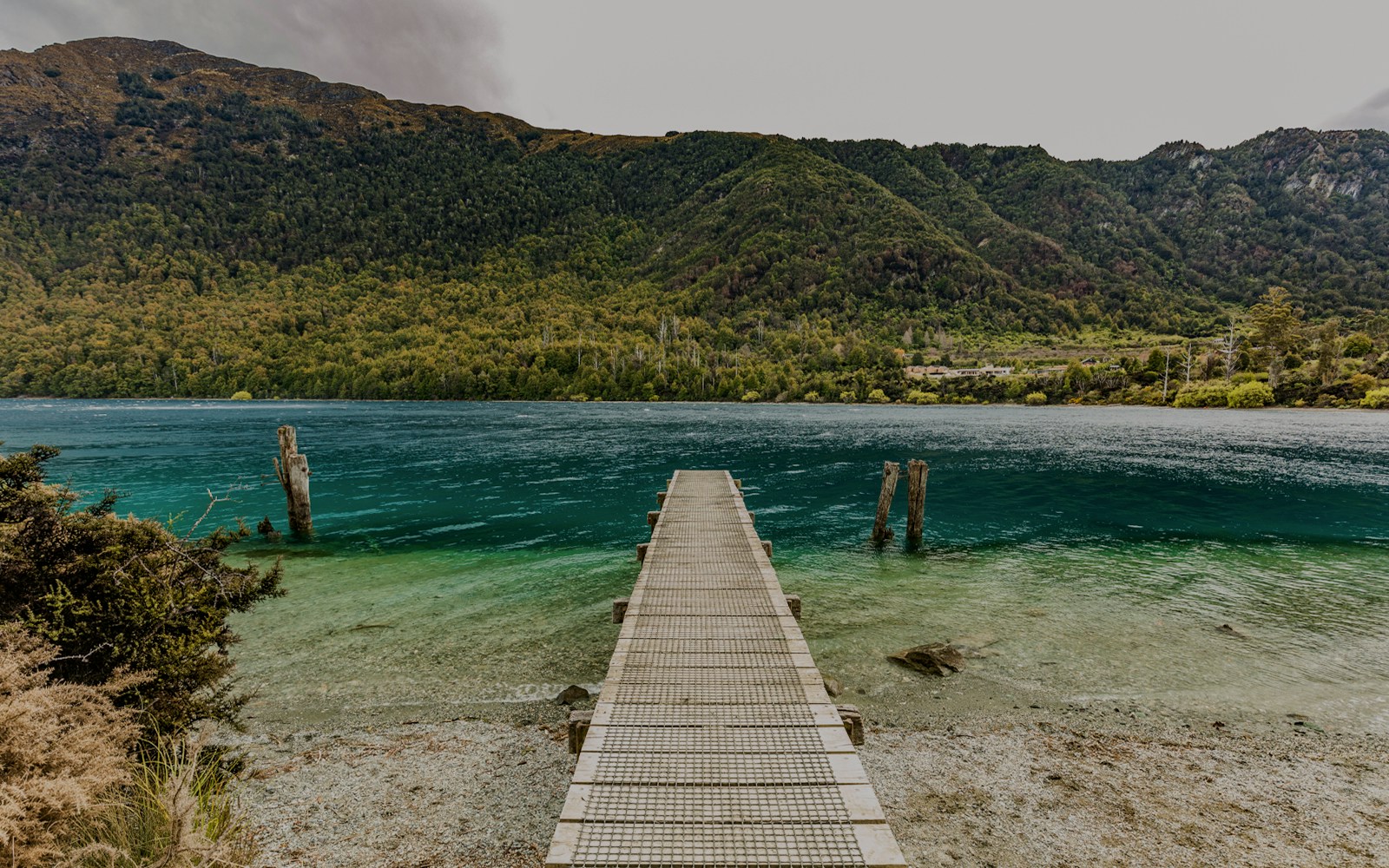 Dock extending into turquoise waters at Bob's Cove, surrounded by lush green hills.