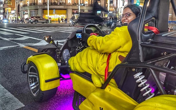 Person in costume driving a go-kart on Tokyo street during Skytree, Ginza, and Imperial Palace tour.