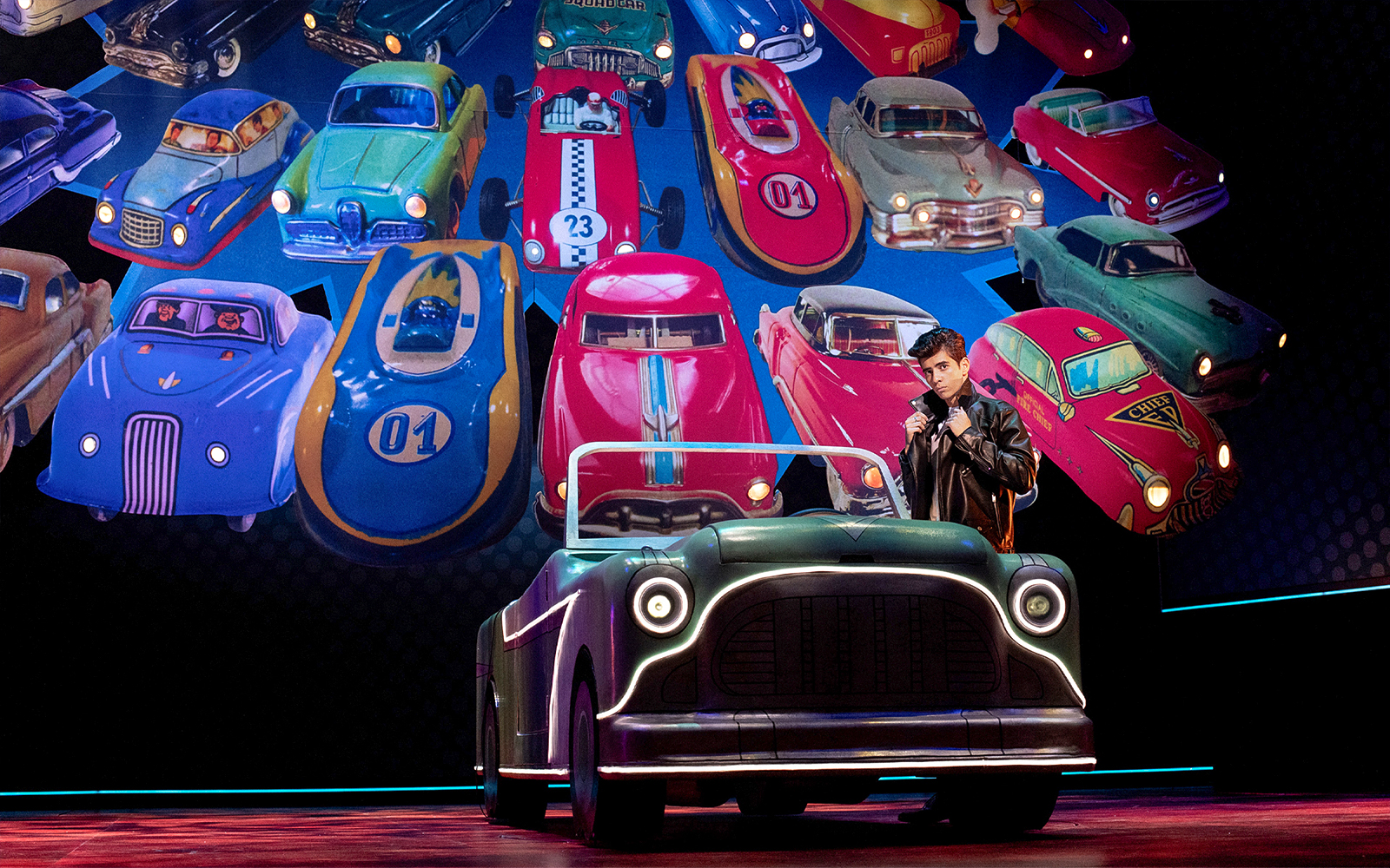 Classic car display with a person in a leather jacket, inspired by Grease.