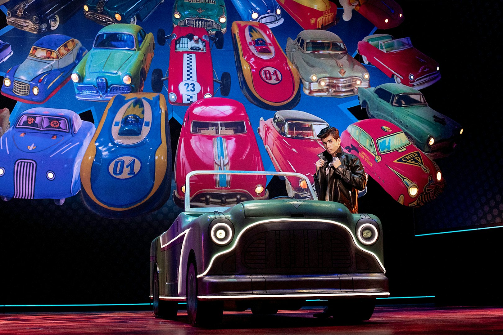 Classic car display with a person in a leather jacket, inspired by Grease.