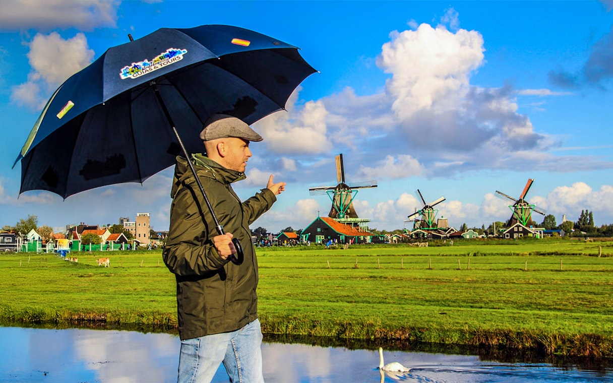 Person pointing at windmills during a guided tour of Zaanse Schans.