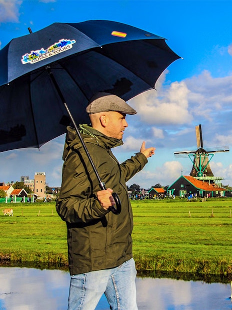 Person pointing at windmills during a guided tour of Zaanse Schans.
