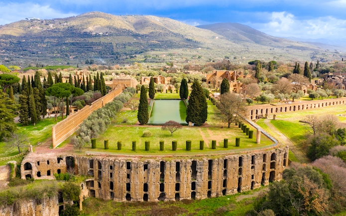 Ancient Roman ruins and gardens at Hadrian's Villa, Tivoli, Rome, with surrounding landscape.