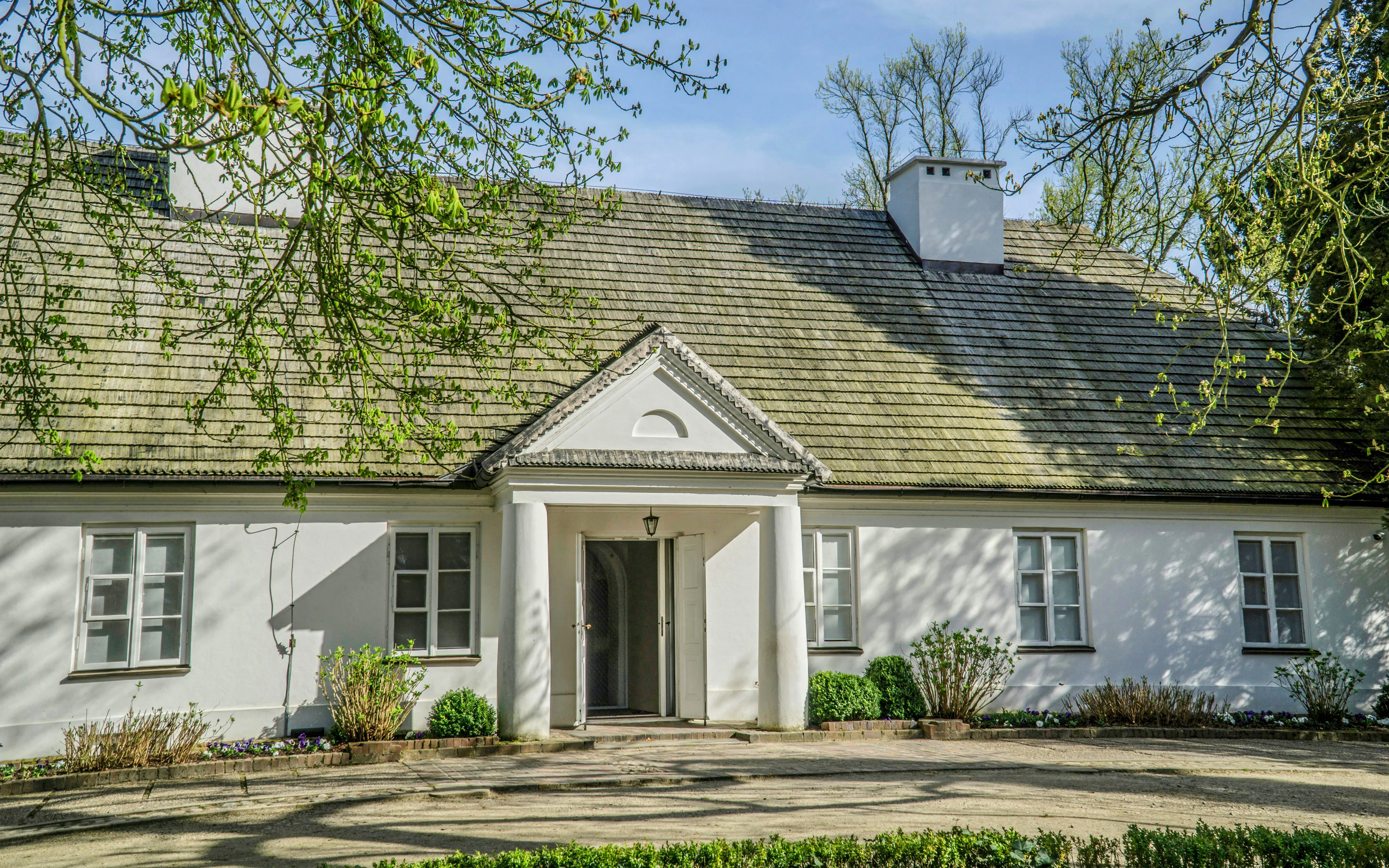 Manor house in Żelazowa Wola, Poland, birthplace of Frederic Chopin, surrounded by greenery.