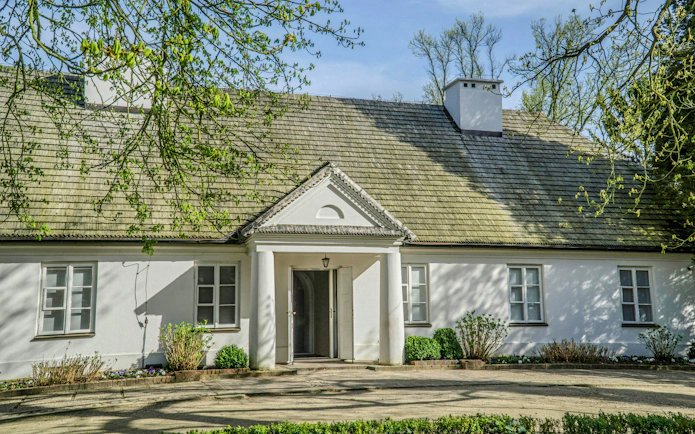 Manor house in Żelazowa Wola, Poland, birthplace of Frederic Chopin, surrounded by greenery.