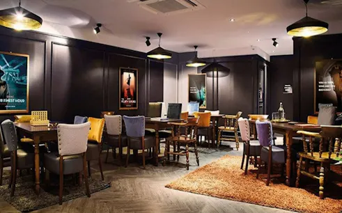 Escape room interior with tables and chairs, part of Aladdin and the Magic Vault experience in Dubai.