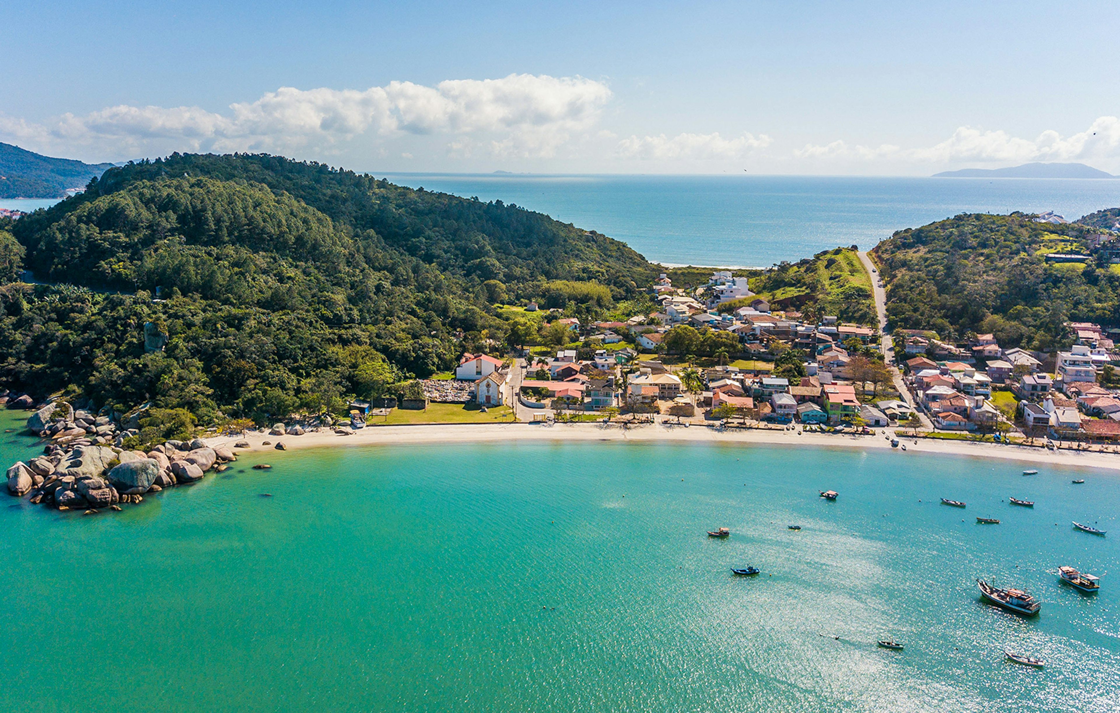 Aerial view of Armação da Piedade beach with boats and coastal village, Brazil.