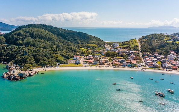 Aerial view of Armação da Piedade beach with boats and coastal village, Brazil.