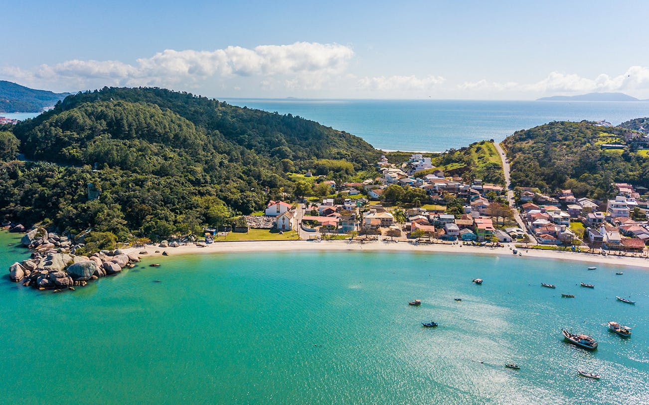 Aerial view of Armação da Piedade beach with boats and coastal village, Brazil.