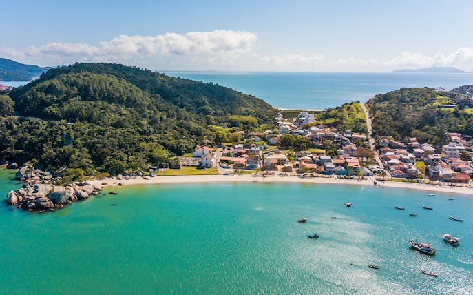 Aerial view of Armação da Piedade beach with boats and coastal village, Brazil.