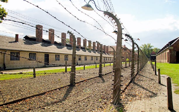 Auschwitz-Birkenau barbed wire fence and barracks on guided tour from Kraków.
