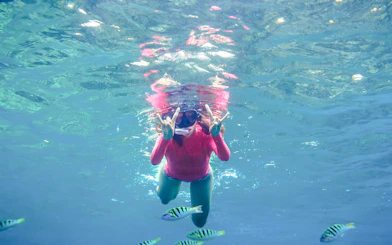 Girl snorkeling with fish in Saint-Jean-Cap-Ferrat, Nice, France.