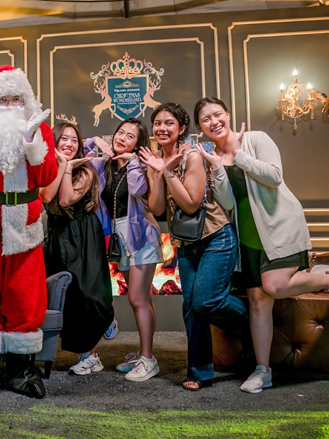 Santa Claus posing with visitors at Gardens by the Bay Christmas event.