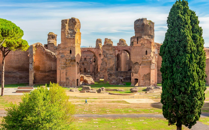 Baths of Caracalla ruins with arches and greenery in Rome, Italy.