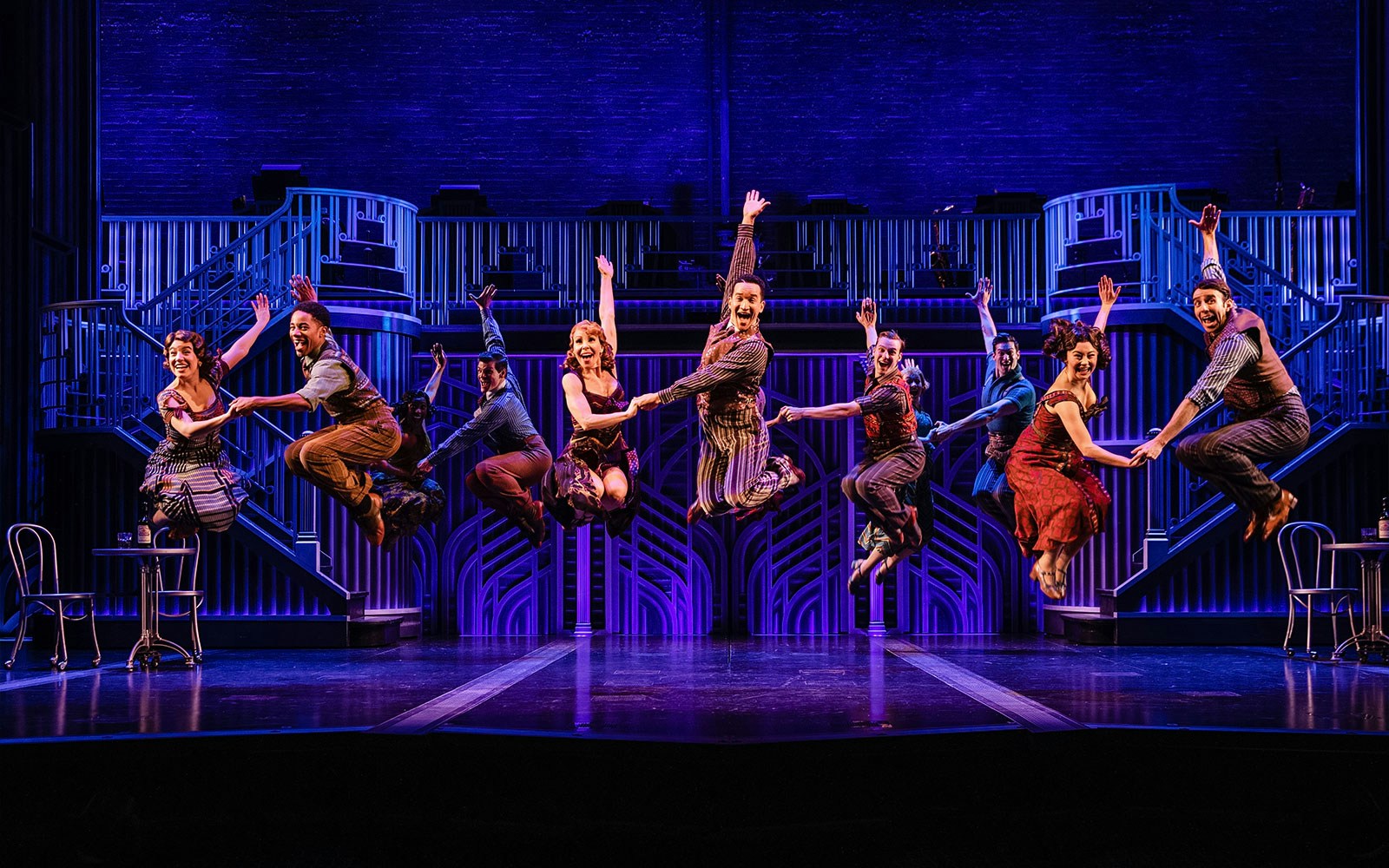 Performers dancing energetically on stage in "Some Like it Hot" musical.