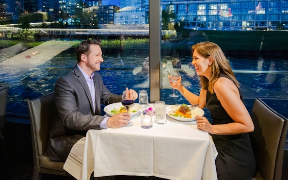 Couple dining on a Chicago dinner cruise with city skyline views.