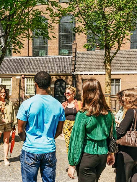 Guide with participants at the Statue of De Dokwerker in Amsterdam.