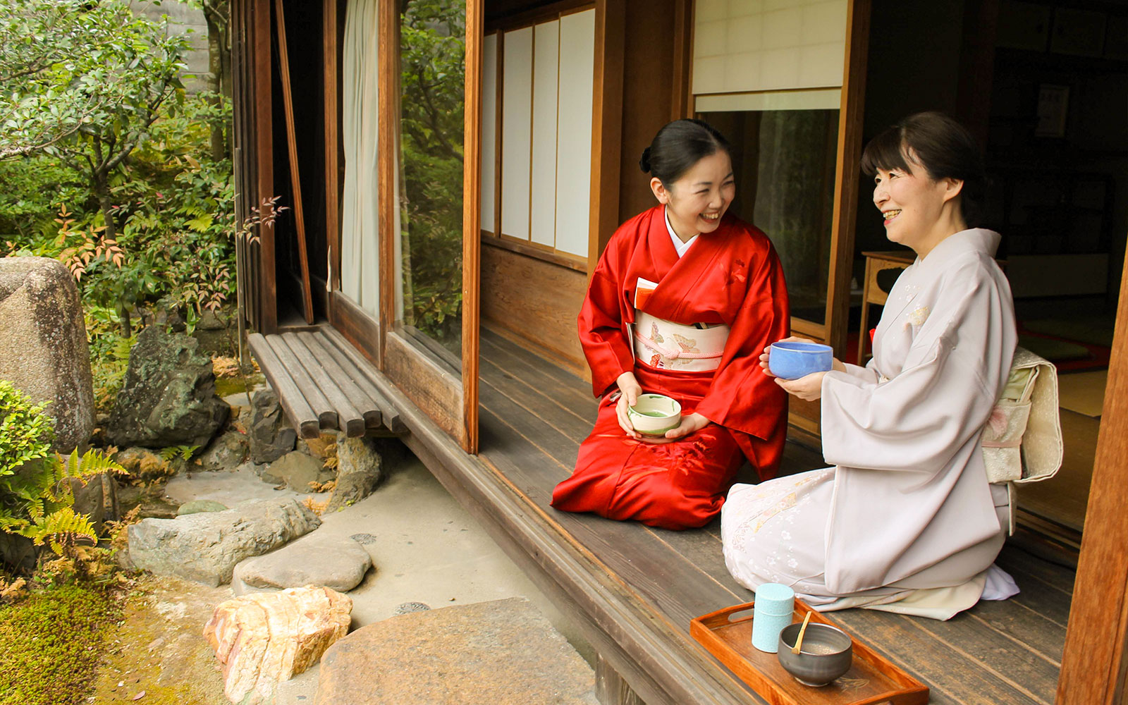 Women in kimonos enjoying a tea ceremony at a garden teahouse in Kyoto.