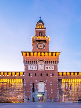 Sforza Castle facade in Milan, Italy, illuminated at dusk.