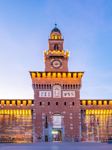 Sforza Castle facade in Milan, Italy, illuminated at dusk.