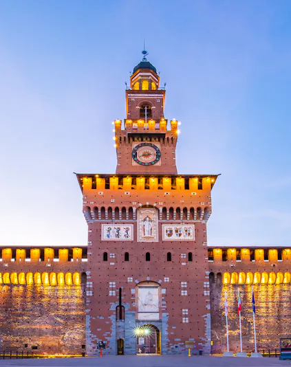 Sforza Castle facade in Milan, Italy, illuminated at dusk.