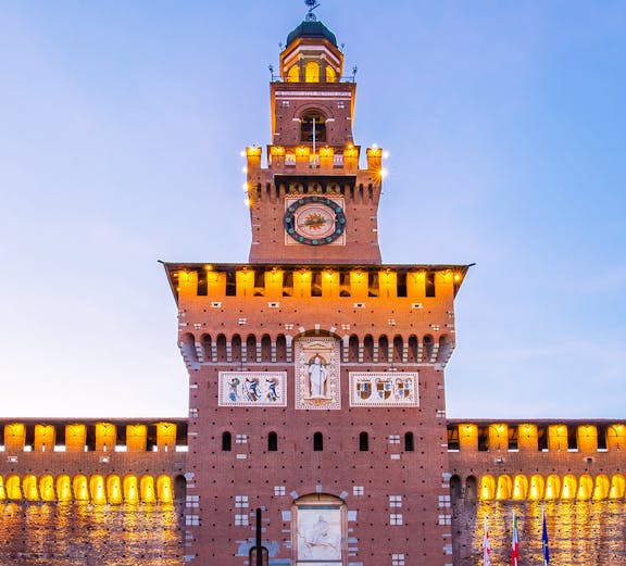 Sforza Castle facade in Milan, Italy, illuminated at dusk.