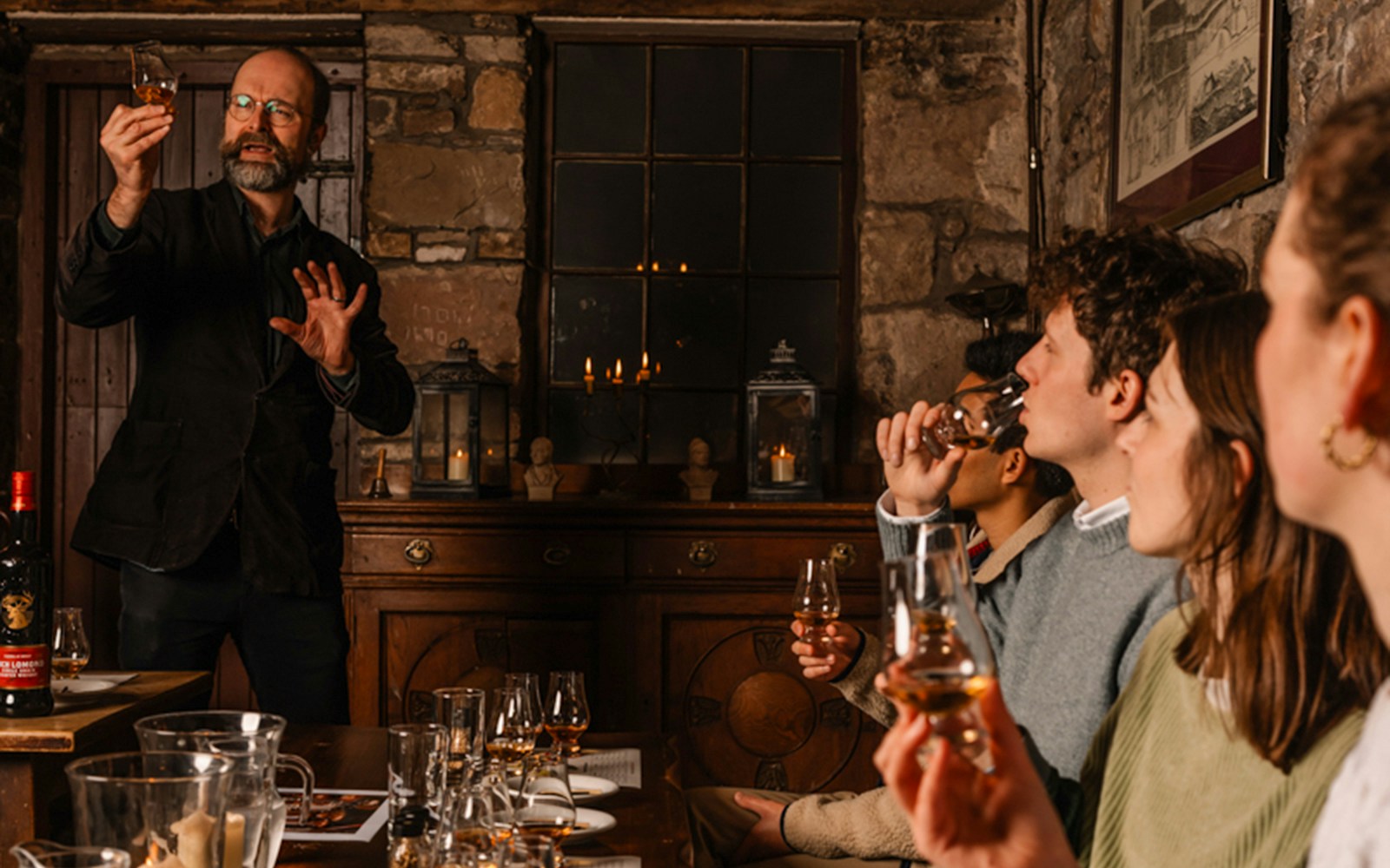 Whisky tasting session in an Edinburgh cellar with a guide explaining to a group.