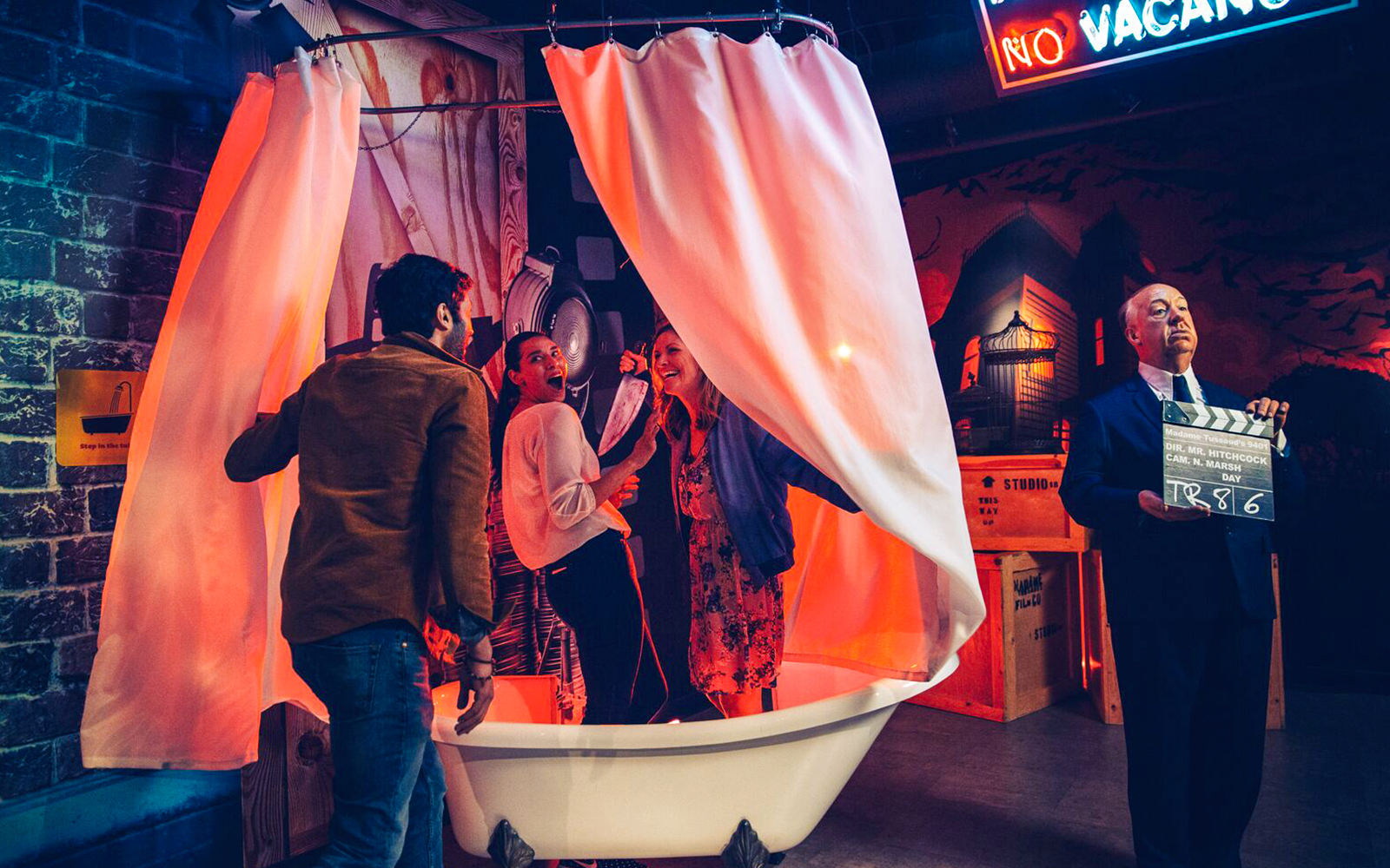 Alfred Hitchcock statue with guests in shower scene at Madame Tussauds Hollywood.