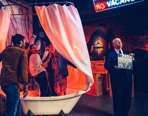 Alfred Hitchcock statue with guests in shower scene at Madame Tussauds Hollywood.
