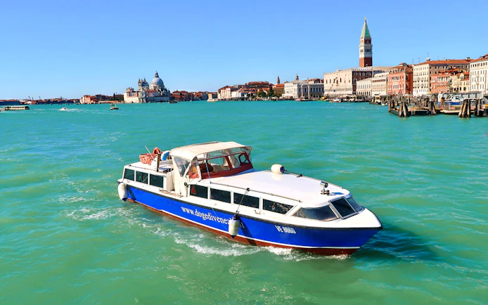 Boat approaching Venice with St. Mark's Campanile and Santa Maria della Salute in view.