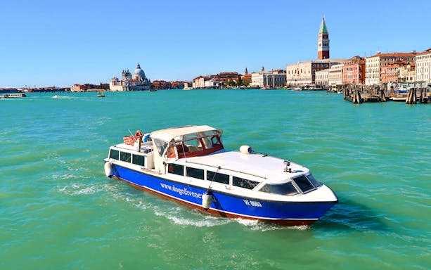 Boat approaching Venice with St. Mark's Campanile and Santa Maria della Salute in view.