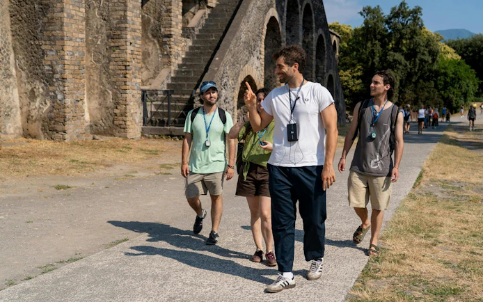 Tour group exploring ancient ruins on a guided tour in Pompeii, Italy.