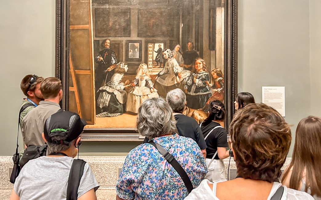 Visitors viewing Velázquez's "Las Meninas" at Prado Museum, Madrid during a guided tour.