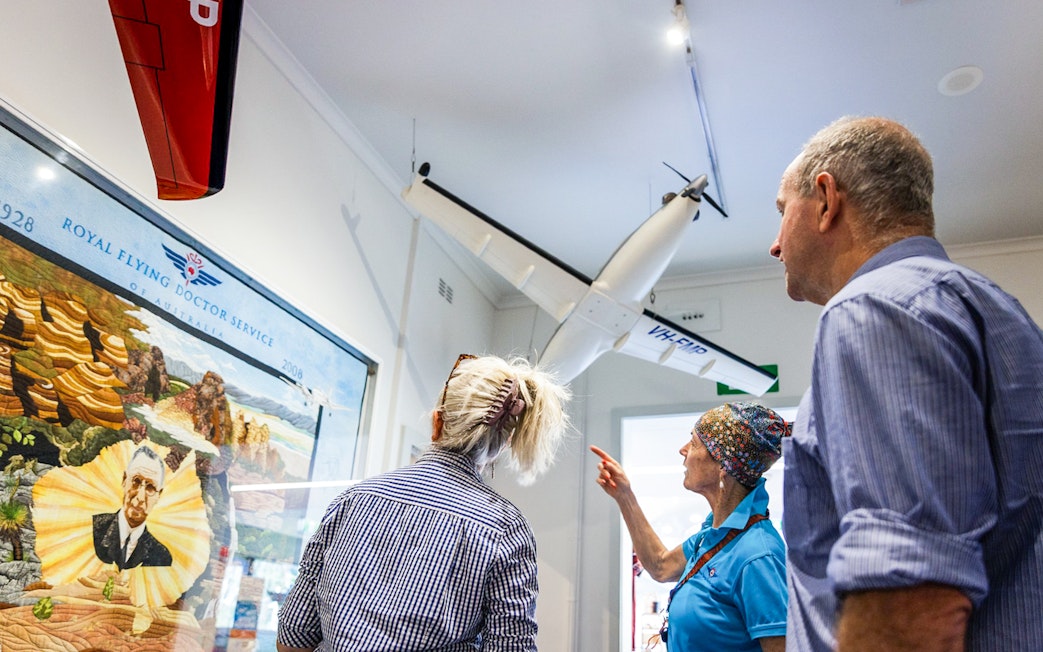 Visitors observing Royal Flying Doctor Service exhibit in Alice Springs museum.